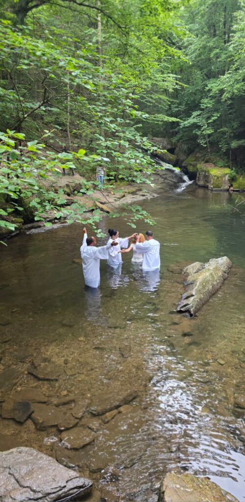 Congregación acompañando un bautismo en el río en Pensilvania